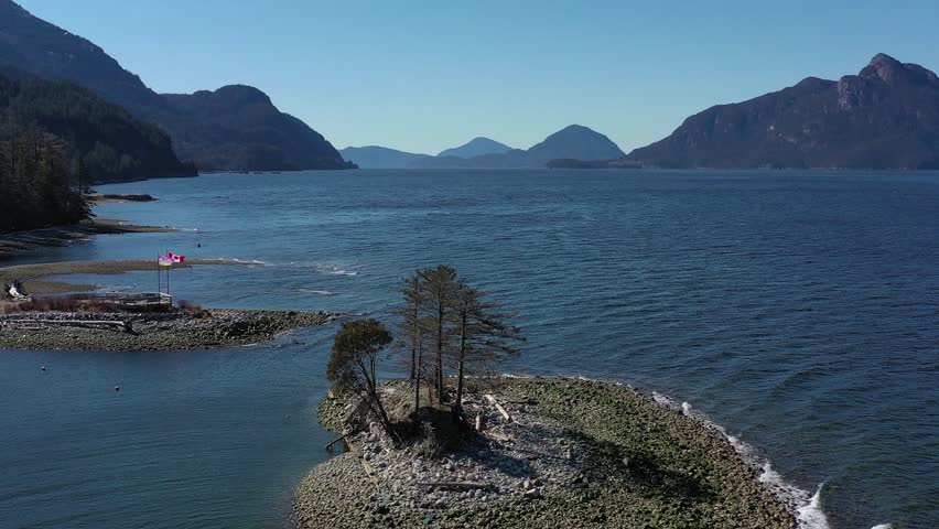 Aerial view over Burrard Inlet, ocean and island with mountains in beautiful British Columbia. Canada. 4K.