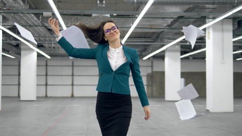 Happy office worker starts to dance and throws away documents.