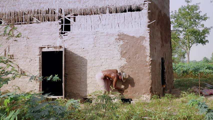  man covering with mud over the entire surface of a tobacco barn for a new use.  ( The restored tobacco barn )