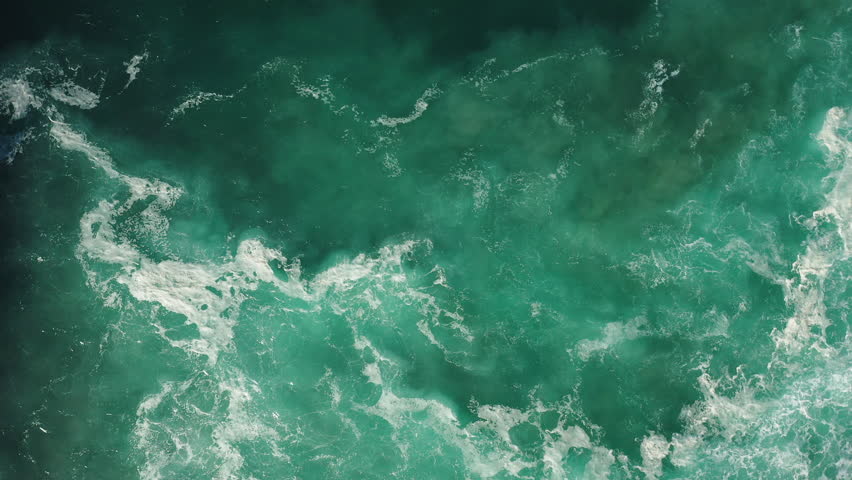 Aerial; view from above; drone shot of crushing wave; white foam, drops of seawater; top down view of emerald water in Nazare; Huge ocean wave during storm, sea water background in rough conditions Royalty-Free Stock Footage #1026036779