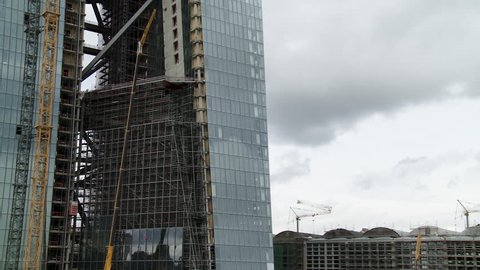 Skyscraper construction on overcast day. Lockdown shot.