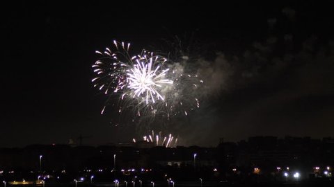 Dazzling fireworks are radiating the night skyline