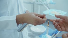 Doctor shows patient veneer samples. 4K slow motion video