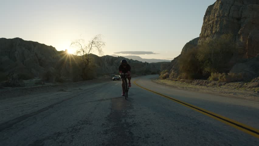 Biker pedaling towards the camera as it moves backwards