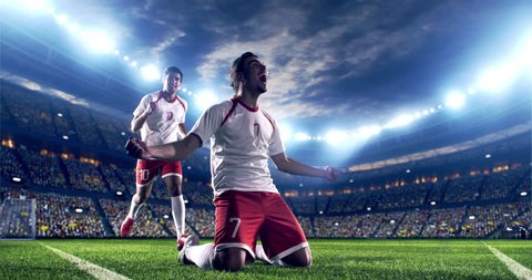 Professional footballer is happy and slides with his hands to the air. Another soccer player runs after him happily. Action takes place on soccer stadium. Stadium and crowd are made in 3D.
