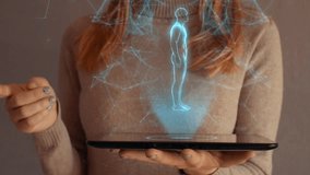 Hologram screen on a tablet with digital human body, skeleton and brain used by businesswoman. Digital projection of mooving particles - Powered by Shutterstock - Get 15% off with code: PIKWIZARD15