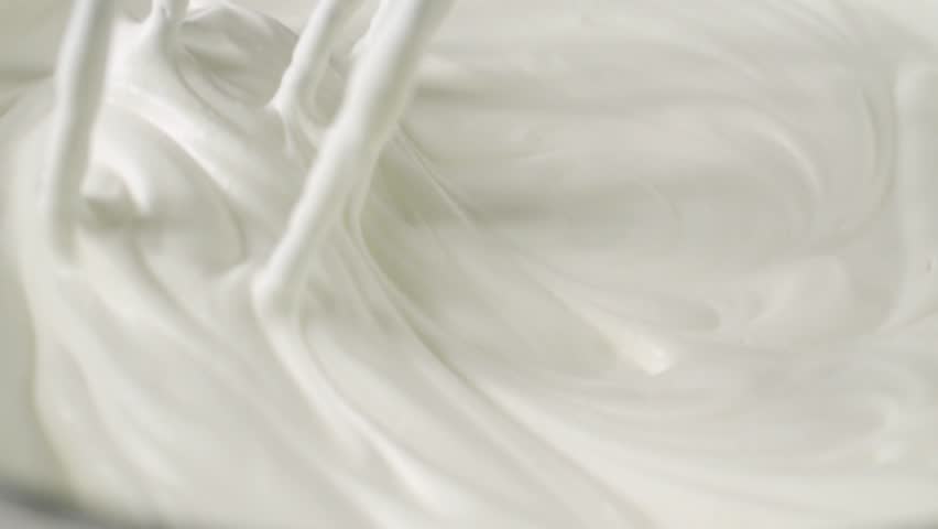 Whipping white cream with a mixer in slow motion Royalty-Free Stock Footage #1026072716