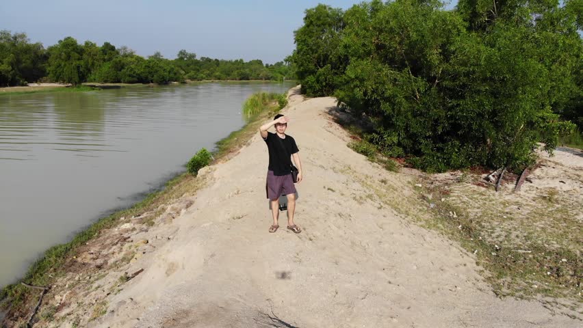 Aerial view young man stand on the edge of island with freedom concept
