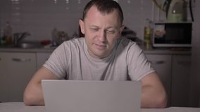 happy man sits at home in the evening for a laptop and chat with someone