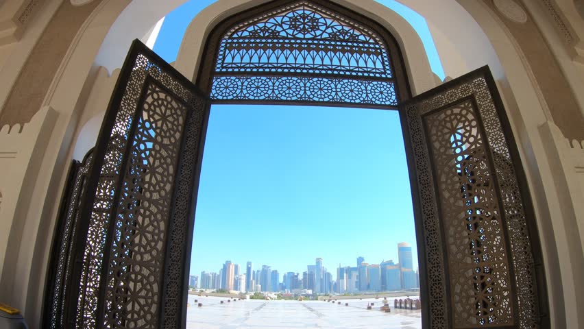 Modern skyscrapers of Doha West Bay skyline view from State Grand Mosque in Doha, Qatar, Middle East, Arabian Peninsula. Door of entrance at Mosque in Arabian style.