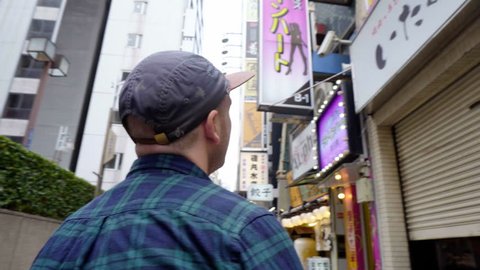 Caucasian Sex Tourist Looking At Strip Club Sign in Red Light District in Tokyo, Japan - September 2018