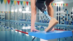 A man with bionic leg jumps into a pool, swimming workout. - Powered by Shutterstock - Get 15% off with code: PIKWIZARD15