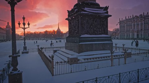 Lanterns and the Alexander Column on the Palace Square near the Hermitage in the snowfall at sunset in St. Petersburg, Russia