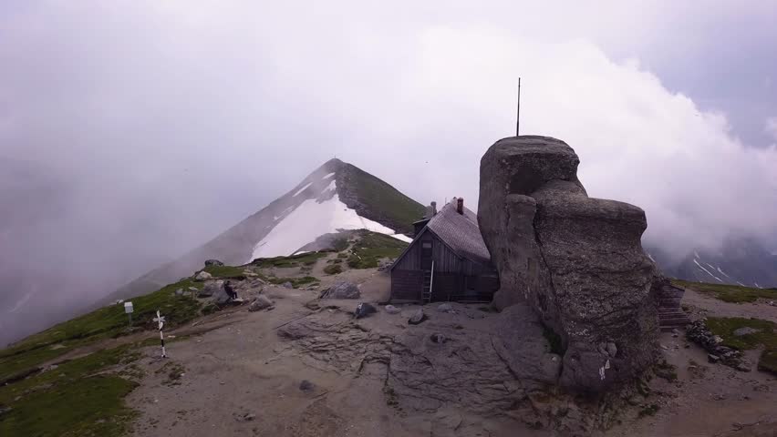 Aerial shot of a Shack on the top of a mountain ridge for climbers and hikers to rest for the night