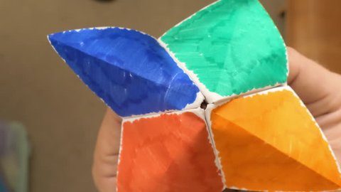 Playing with folded paper fortune teller, classic children’s game  库存视频