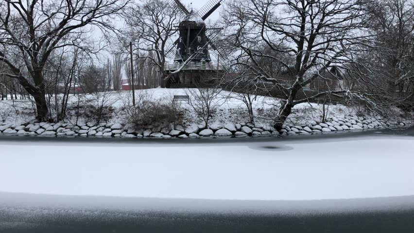 Windmill with snow across frozen river