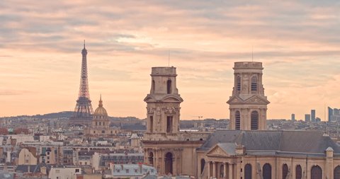 City of Paris France at Sunset with aerial view by drone on saint sulpice cathedral and Eiffel Tower, with full city cityscape and dawn colors