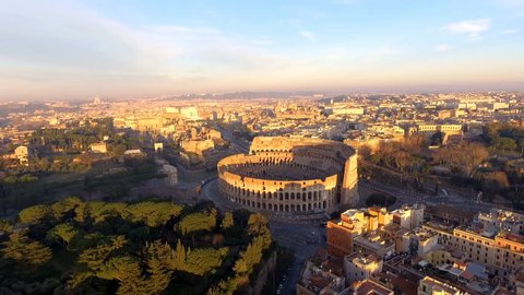 Flying over Colosseum, Rome, Italy. Aerial view of the Roman Coliseum on sunrise