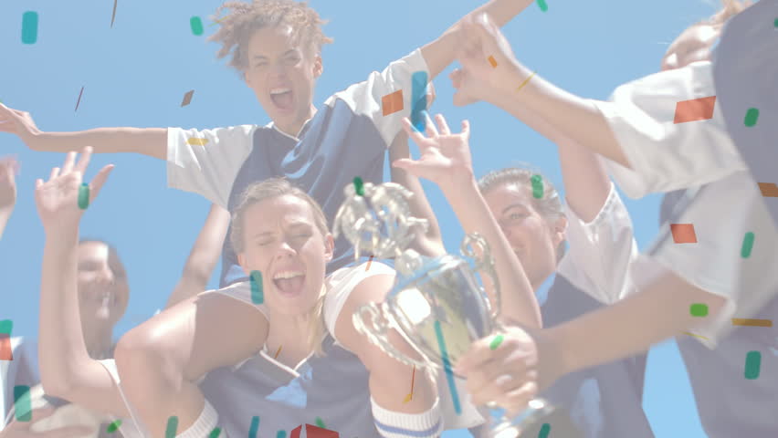 Digital composite of female team of soccer players cheering while colourful confetti falls down. One girl holds the cup while another girl holds soccer ball.
