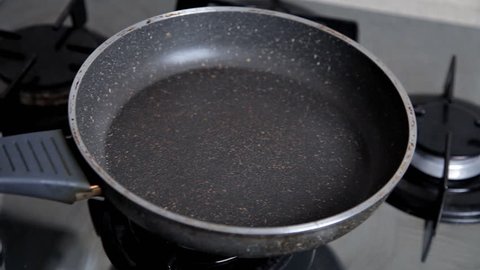 Pouring liquid dough on a hot pan while frying pancakes
