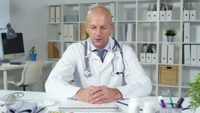 Sequence of videos with male doctor prescribing medicines to ill middle-aged Caucasian woman sitting at kitchen table at laptop by video call