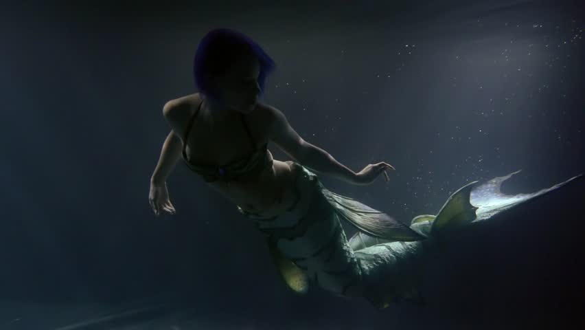 magic slim and beautiful female mermaid is swimming in deepness of ocean, waving her long tail Royalty-Free Stock Footage #1026136655