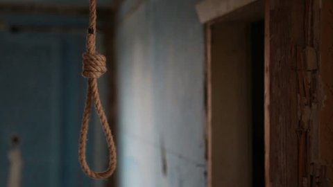 A rope loop for suicide hangs in a wooden hut. Suicide in an abandoned house.
