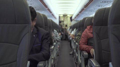 Passengers sitting on seats aircraft while flying in sky. Passengers inside cabin commercial plane while flight. Air traveling by modern commercial airplane