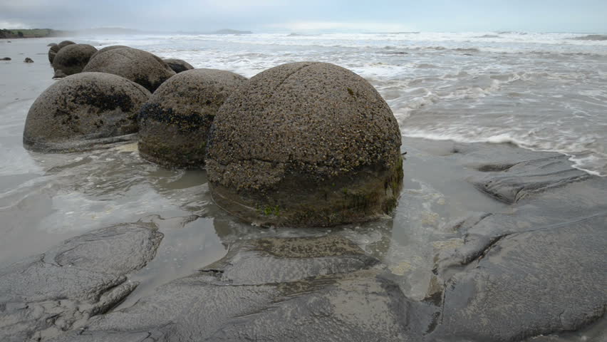 Impressive Moeraki boulders in the Pacific Ocean waves