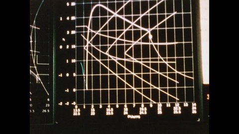 1960s: Graph in NASA mission control room of rocket trajectories. Man looking at charts. Charts on display in mission control. Men in mission control. Man looking at graph. Men in front of console.