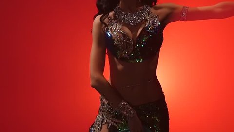 Woman belly dancer arabian in exotic dress dancing. Red smoke background. Slow motion. Close up