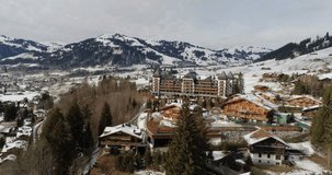 The Alpina Gstaad hotel in winter snowfall - Aerial 4K