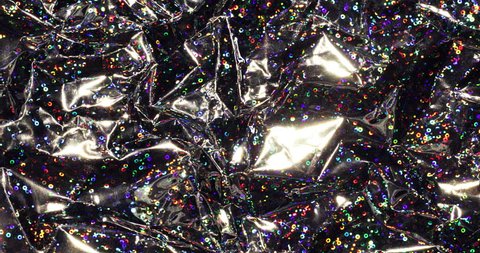 Glittering holographic iridescent metallic wrapping foil radiant background