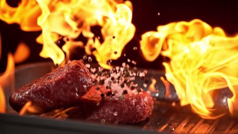 Super slowmotion footage of throwing fresh beef meat burger and pepper on ignited pan, 1000fps 4k