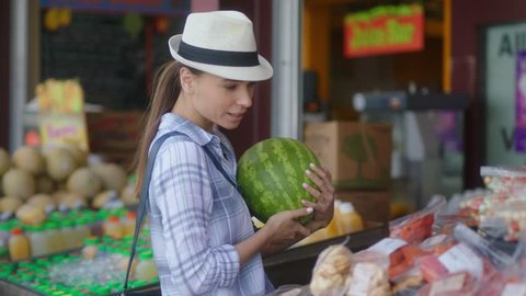 Woman walking with a watermelon at farmers market picking up vegetables and fruits / Buying healthy food