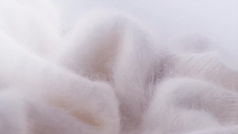 Soft Mohair Wool background. Alpaca wool mohair clothes texture closeup. Natural Cashmere Soft and fluffy merino wool macro shot. Woolen fabric. Knitted hairy detail texture Rotated. 4K UHD slowmo
