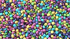 4K HD video of background of candy coated chocolates in pastel colors, chop stick reaches in and deposits one candy then removes another. Easter colors