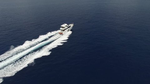 Perpendicular aerial view yacht cruising in the Mediterranean at full speed
