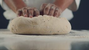 Baker kneading dough in flour on table. Slow motion video 4K