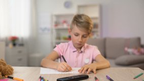 Male kid watching television instead drawing, changing channels remote control