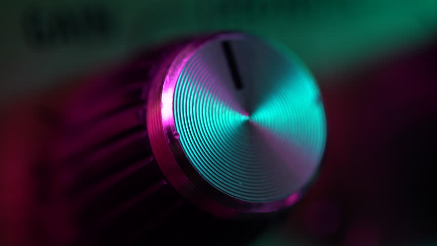 View of the control panel on a guitar amplifier. Tumblers, knobs and buttons. Male hand turn on and increasing music volume on amp. Colorful neon light. Macro view. Royalty-Free Stock Footage #1026197198
