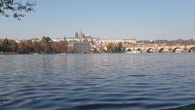 Timelapse panorama of Charles bridge, Prague Castle and Vltava river. Catamarans and ducks on the Vltava river. Czech Republic