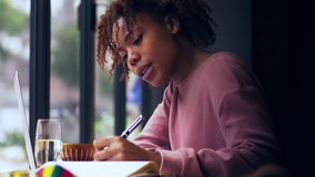 Young African college girl student study. Black female writer writing note education clip. urban freelancer lifestyle in cafe. businesswoman working in the office. happy girl writing letter
