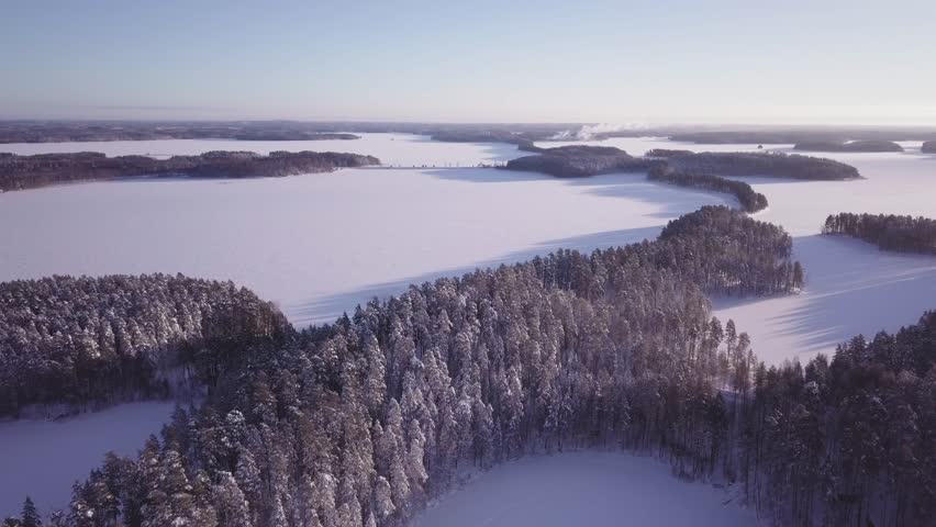 Punkaharju ridge road and frozen lake Saimaa. Aerial view of Finnish national ladscape in winter.