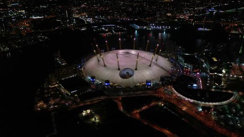 Greenwich Peninsula, London / United Kingdom - March 18 2019: Aerial drone bird's eye night view of iconic concert Hall of O2 Arena