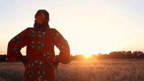 
HD Video clip of African woman farmer in traditional clothes standing in a farm field of crops in Africa at sunset or sunrise
