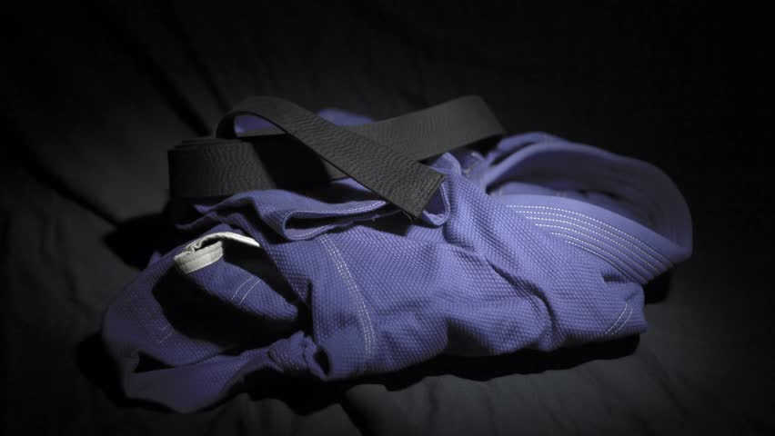 Blue kimono for jujitsu, with a black  belt close-up on a dark background Royalty-Free Stock Footage #1026221978