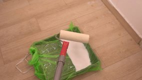 Person transferring paint onto a roller