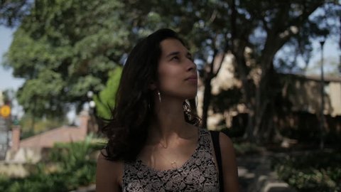 Diverse Young Woman Walks Through Park with Dappled Light - Mid Close Up from Front - Cinematic Slow Motion