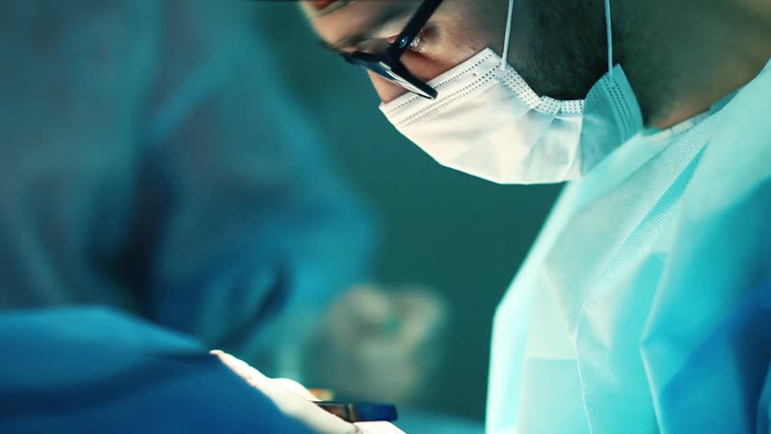 male surgeon doctor in glasses operates a patient in the operating room. Royalty-Free Stock Footage #1026250229